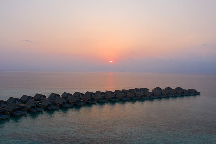 Maldivler balayi icin gun batiminda overwater villa